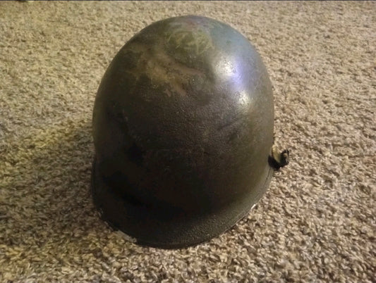 Authentic WWII U.S. Army M1 steel helmet shell, featuring honest battlefield wear and a hand-painted soldier name: “Keane”